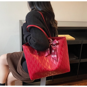Detail of red tote bag with quilted pattern and decorative silk scarf with character