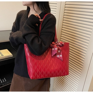 Detail of red tote bag featuring quilted rhombus pattern and traditional silk scarf wrap