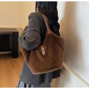 Vue détaillée du sac seau en fausse fourrure marron avec bandoulière en cuir et fermoir en métal