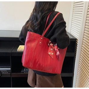 Detail of red water ripple texture tote bag with silk scarf on a model's shoulder