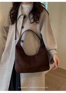 Deep brown suede Hobo shoulder bag worn by a model in a minimalist retro style outfit