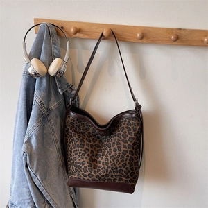 Close-up of leopard print canvas tote with brown leather stitching details