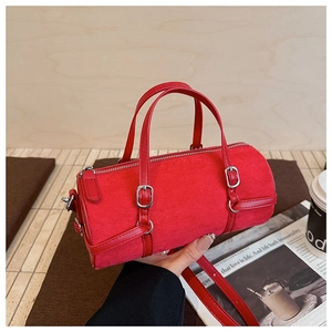 Detail of red suede bowling bag with silver hardware and detachable shoulder strap