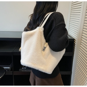 Détail d'un sac cabas en fausse fourrure blanc crème avec une boucle en métal argenté