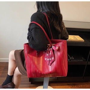 Detail of red textured leather tote bag with elegant wedding scarf and large capacity