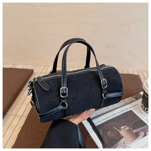 Detail of a black bowling bag with suede texture and decorative silver buckles
