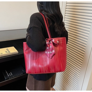 Detail of red tote bag with wave texture and purple silk scarf featuring Xi character