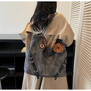 Detail view of deep grey tote bag with matte texture and cute plush donut charm