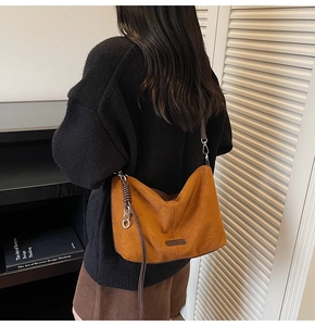 Detailed view of caramel suede hobo bag with silver chain and leather shoulder strap