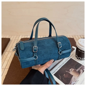 Detailed view of dark green suede bowling bag with silver zipper and dual handles