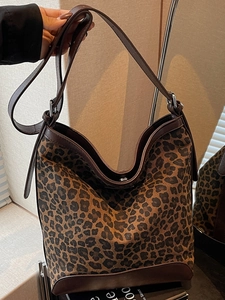 Large capacity leopard print bucket bag with brown leather trim and adjustable strap