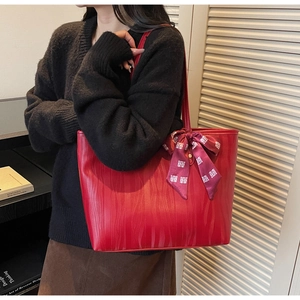 Detail of red textured tote bag with wave pattern and traditional knot silk scarf