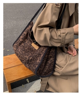 Close-up of leopard print suede tote bag with HOPEFUL leather patch on wooden bench