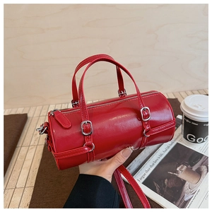 Macro shot of glossy red cylinder bowling bag with silver hardware and leather texture