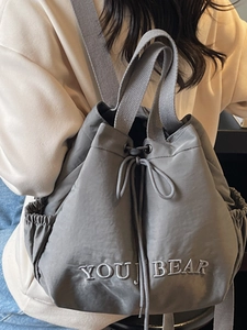 Grey drawstring bucket backpack with YOU BEAR embroidery and lightweight nylon fabric