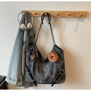Detail of dark grey tote bag with soft vintage texture and cute plush donut charm