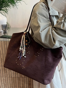 Large brown suede tote bag with gold rivets and colorful tassel charm for women