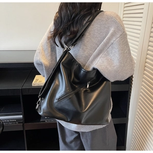 Detail showing high-capacity black PU leather tote bag with stylish diagonal metal zipper