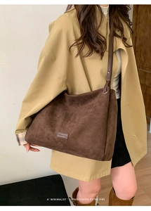 Detail of dark brown frosted leather shoulder tote bag on model for a retro minimalist vibe