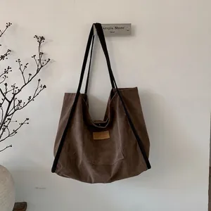 Detailed close-up of dark brown suede tote bag with HOPEFUL leather tag and vintage texture