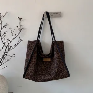 Detail of leopard print suede tote bag with HOPEFUL leather patch and black strap handles
