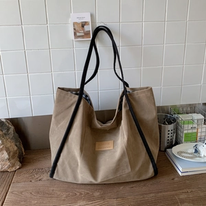 Detail showing the blue and white checkered inner lining of the khaki canvas tote bag