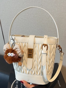 Elegante borsa a secchiello trapuntata bianca con chiusura in bronzo e charm peluche