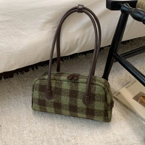 Close-up of green and brown checkered wool shoulder bag with long leather handles