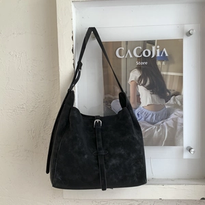 Close-up of vintage black hobo bag with matte texture and silver metal buckle detail