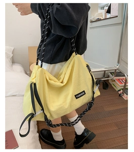 Détail du grand sac bandoulière en nylon jaune avec sangle en corde tissée de style urbain