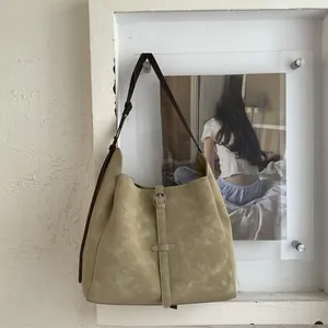 Detail of vintage grey-green large capacity bucket bag with brown adjustable straps