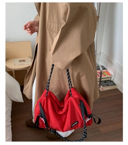 Gros plan du sac fourre-tout en nylon rouge imperméable avec poignée en corde tressée