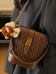 Borsa a secchiello marrone in pelle a pieghe con fibbia dorata e ciondolo di peluche