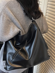 Retro large black leather shoulder bag shown on model with adjustable strap