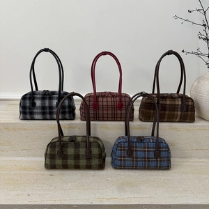 Multiple retro plaid tweed shoulder bags in various colors displayed on stone steps