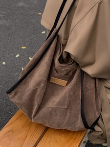 Brown faux suede tote bag with HOPEFUL patch and black trim shown in an autumn street setting