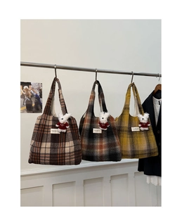 Detailed close-up of wool plaid tote bags in three colors with cute bunny charms