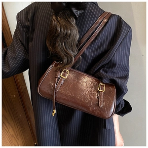 Vue détaillée du sac baguette vintage marron foncé en cuir ciré brillant avec boucles dorées