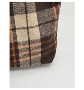 Close-up of durable brown plaid wool fabric texture for high-capacity shoulder bag