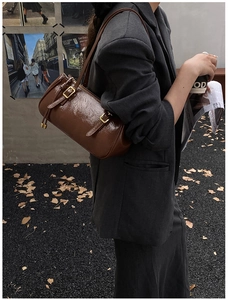 Détail du sac à bandoulière en cuir huilé brillant marron avec boucle de réglage en métal