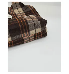 Detail shot of the reinforced bottom seam on this plaid wool shoulder tote bag
