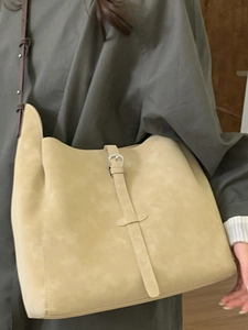 Minimalist beige suede hobo bag with vintage buckle detail and brown leather strap