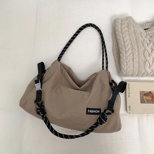 Détail de la besace kaki en nylon avec une bandoulière en corde tressée au style tendance