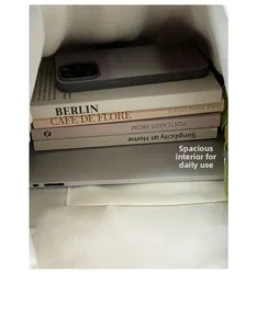 Spacious interior of plaid tote bag holding a laptop, books, phone, and folding umbrella