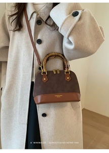 Close-up of retro shell bag with leopard patch, bamboo handle and metallic zipper details