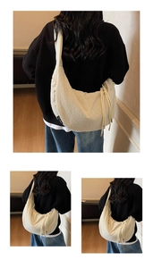 Detail of beige crescent bag showing bubble textured fabric and drawstring detail