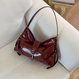 Dettaglio della borsa in vernice rosso scuro lucido con chiusura in metallo argento