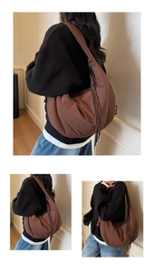 Detail of a large brown hobo bag featuring textured fabric and long decorative side tassels
