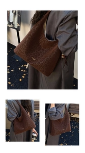 Detail of dark brown leopard print hobo bag with gold logo and wooden bead charm