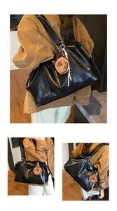 Detail of black large capacity tote bag with plush charm and striped strap accent
